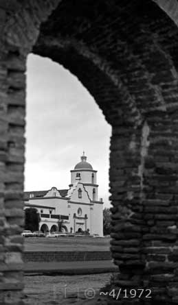 B/W photo: Mission framed in archway - Embedded text: ~4/1972