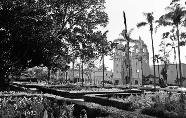 B/W photo: View of garden with Casa del Prado across street - Embedded text: 1973