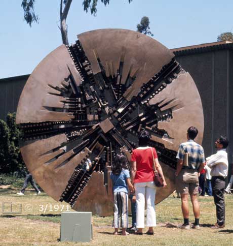 Color photo: Tourists observing  large metallic disc art  piece on Fine Arts Museum grounds- Embedded text: 3/1971