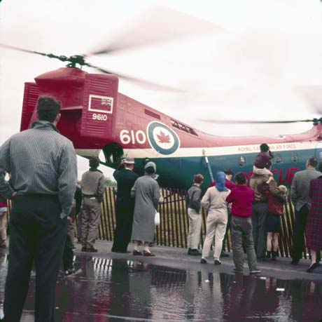 color photograph: helicopter w/blades reving up and airshow viewers in foreground