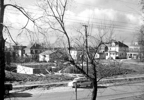 grayscale photograph: elevated view of home construction accross street