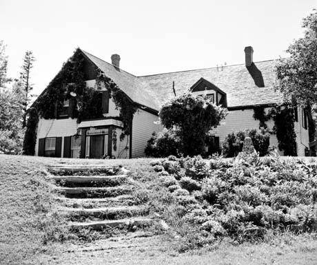 grayscale photograph: front view of house w/ steps in foregroundr