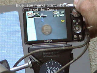 Hand adjusting zoom of tripod mounted camera