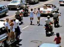 Color photo: Elevated view of Olympic Torch runner just passed by