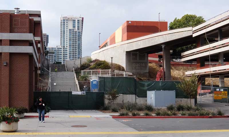 Fenced off staircase between school buildings - downtown skyscraper in background
