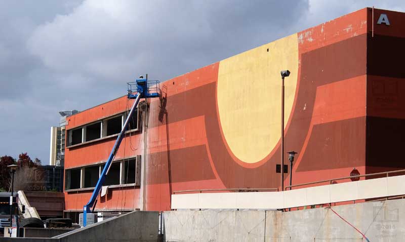 Worker in cherry-picker working on face of "A" building shell - oblique view