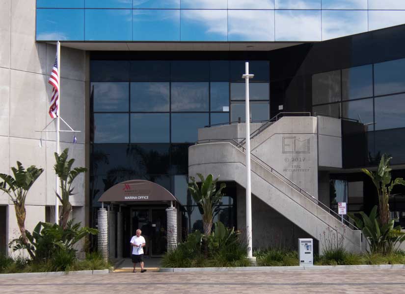 View of architecurally interesting marina office building as man leaves with a a brochure