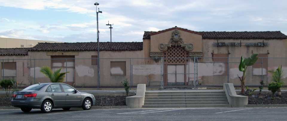 Wide view of fenced off abandoned building wide stairs leading up to main entraance
