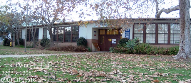 Original West City Campus building with fallen leaves on front lawn