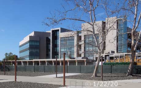 Concourse in foreground, buildings beyond fence