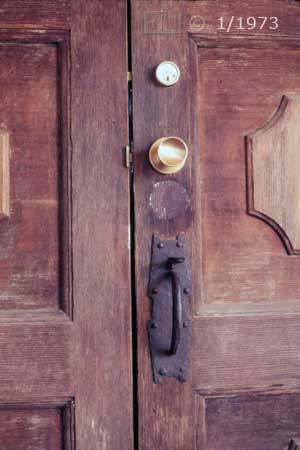 Color photo: Old door with new locks - Embedded text: 1/1973