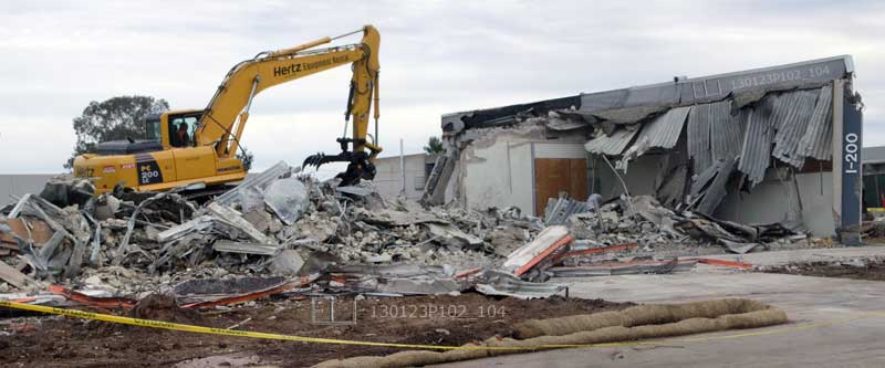 Excavator demolishing and crushing Mesa College building I-200