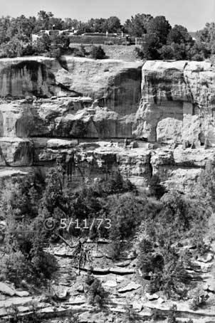 B/W photo: Wide view of Sun Temple ruins on plateau/mesa and ruins on side of cliff - Embedded text: 5/11/73