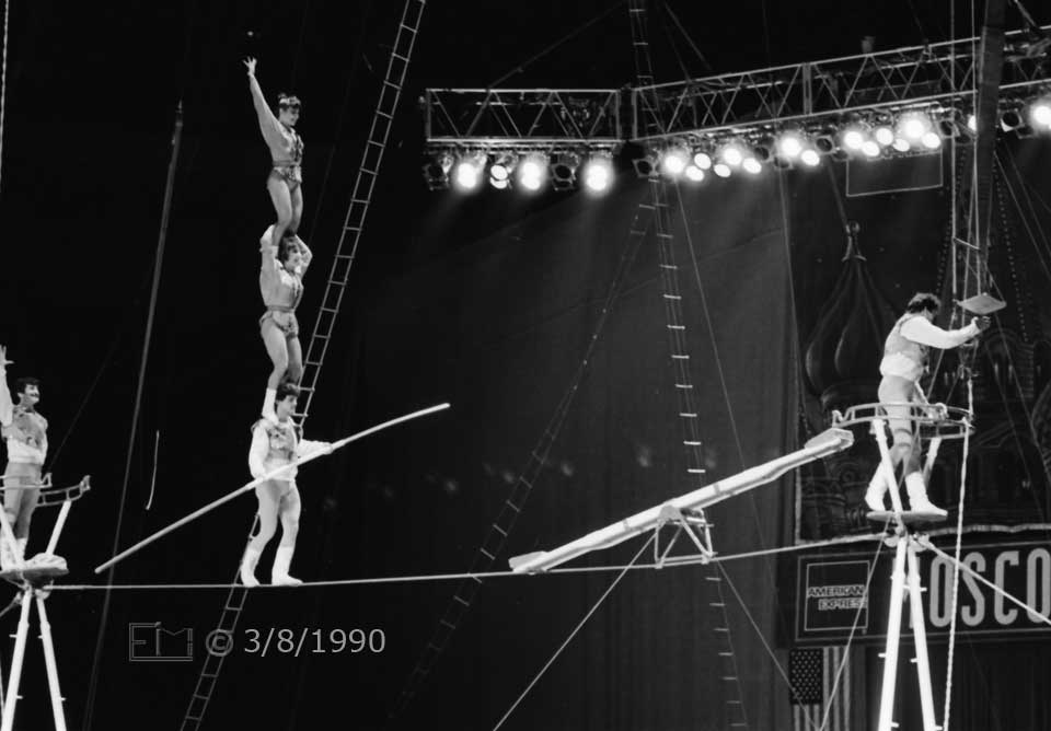 B/W photo: Success > Column of 3 performers atop each other on a tightrope - Embedded text: 3/8/1990