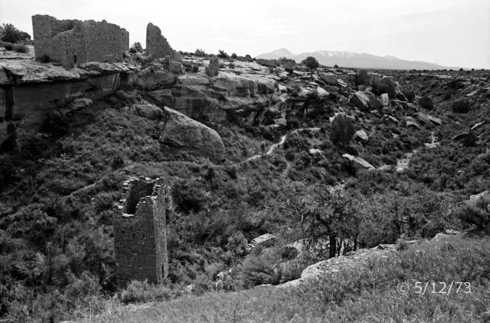 B/W photo: Square tower ruin in canyon and  ruin on masa beyond - Embedded text: 5/12/73