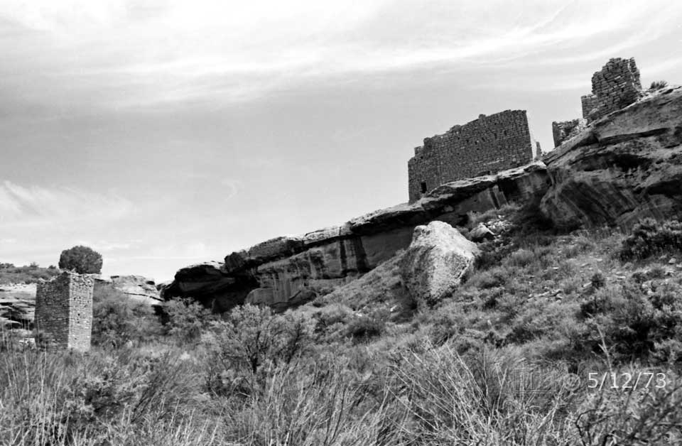 B/W photo: View from within canyon of Square Tower ruin, canyon wall and ruins on mesa above - Embedded text: 5/12/73