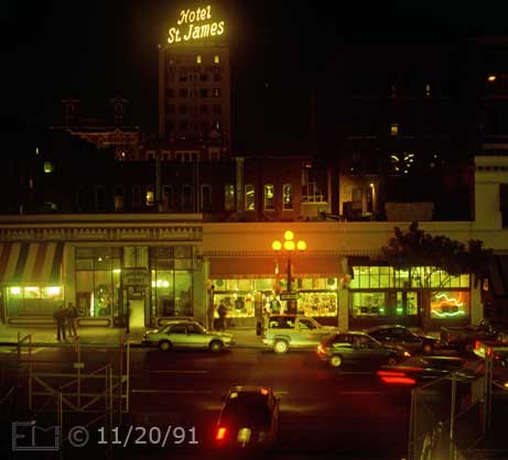 Color photo: Elevated view of 4th ave. storefronts and traffic from East side of Horton Plaza - Embedded text: 11/20/91