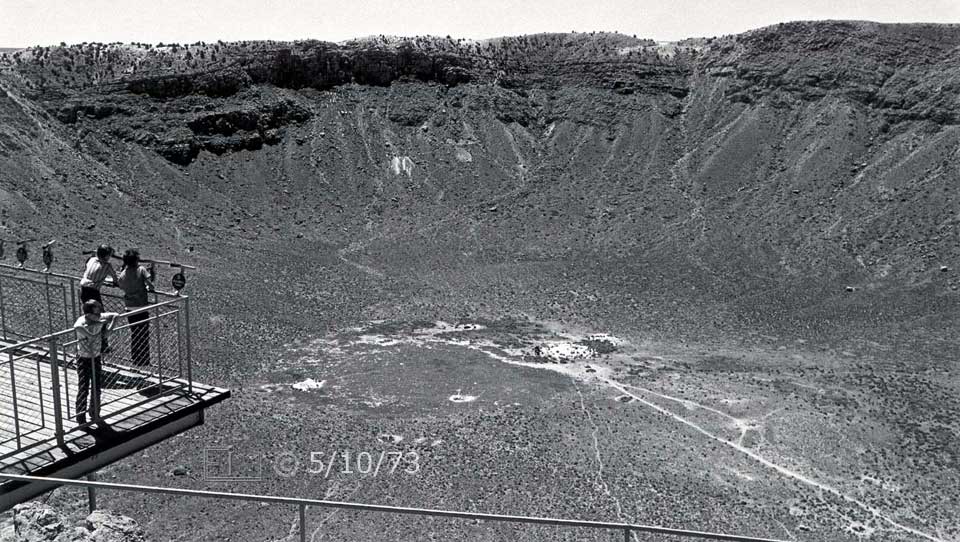 B/W photo: Tourists on platform overlooking a wide and deep crater - Embedded text: 5/10/73