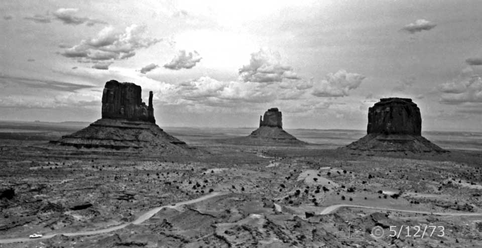 B/W photo: Roadway in foreground leading to 3 massive buttes in distance - Embedded text: 5/12/73