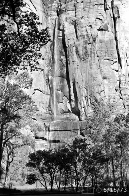 B/W photo: Stream waterfall from near top of high vertical cliff; framed by trees - Embedded text: 5/15/73