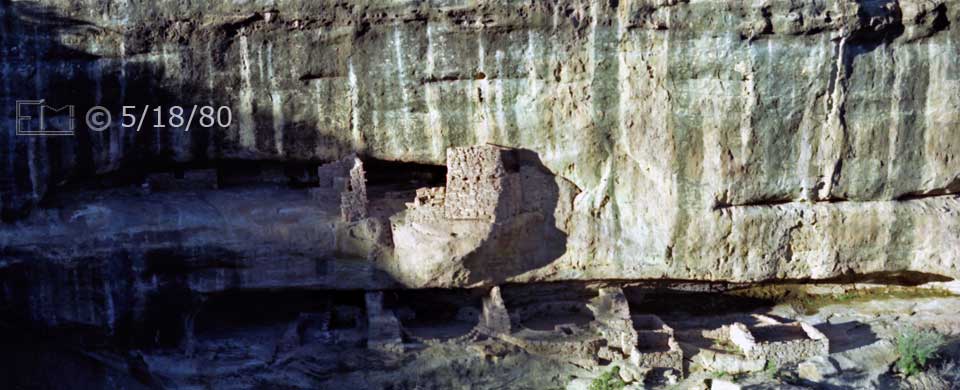 Color photo: Front landscape view of cliff dwelling ruins from across canyon - Embedded text: 5/18/80