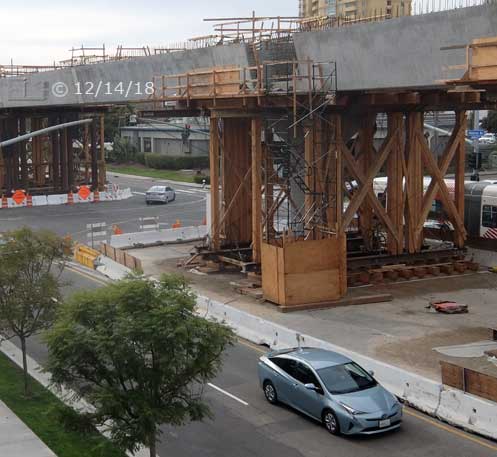 Color photo: Elevated view of trolley line construction at Genesee Ave/Esplanade Ct intersection - Embedded text: 12/14/18