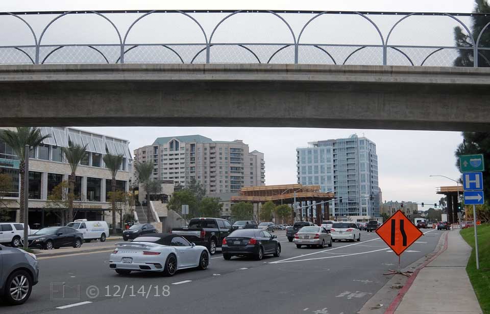 Color photo: West looking sidewalk view of La Jolla Village drive and pedestrian bridge - Embedded text: 12/14/18