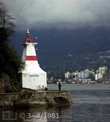 Color photo: High tide view of lighthouse, man fishing and apartment blocks on far shore  - Embedded text: 3~4/1981