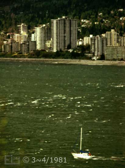 Color photo: Elevated view of small sailboat with North Vancouver on far shore - Embedded text: 3~4/1981