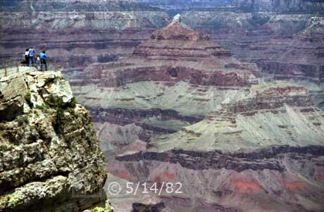 Color photo: Spectators on an overlook view the Temple of Isis and Cheops Pyramid across canyon - Embedded text: 5/14/82