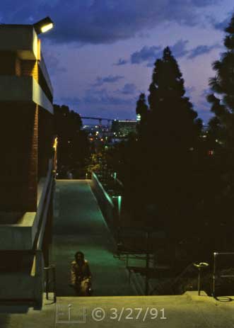 Color photo: Elevated view of stair-way on the West side of 'L' building, during heavy twilight - Embedded text: 3/27/91