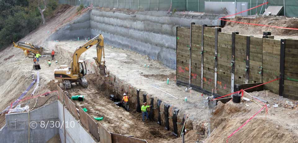 Color photo: Construction of large retaining wall begins - Embedded text: 8/30/10