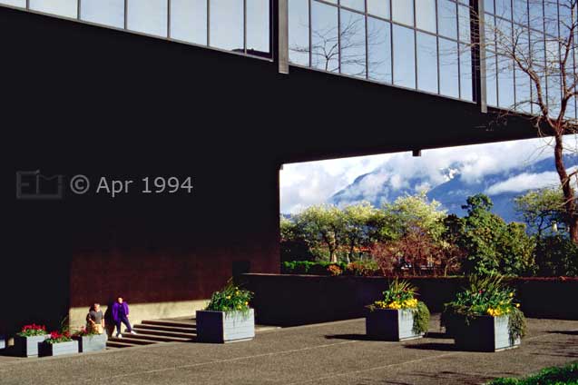 Color photo: Clouded mountains framed by underside of 'QUBE' building - Image taken: 4/7~12/1994