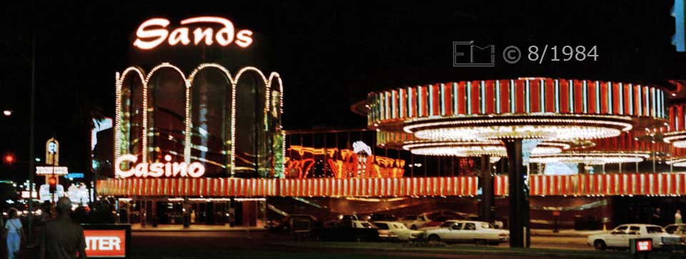Color photo: Nighttime view of 'Sands' casino - Embedded text: 8/1984