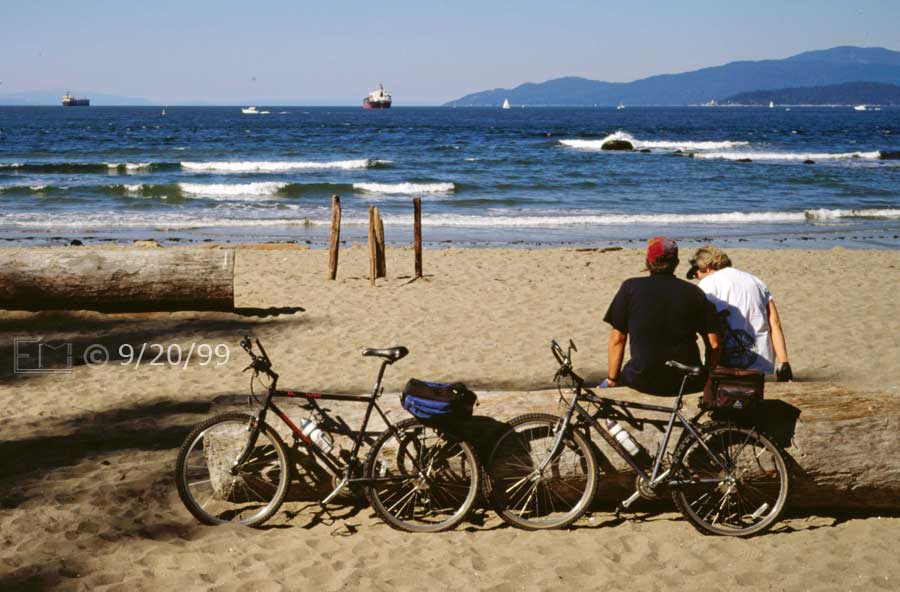 Color photo: Cyclists take a moments rest on a Vancouver beach - Embedded text: 9/20/99