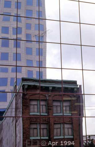 Color photo: Old and newer building reflected on the glass wall of another building - Image taken: 4/7~12/1994