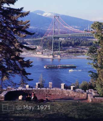 Color photo: View from Stanley Park of vessels passing underneath Lions Gate Bridge - Embedded text: May 1971