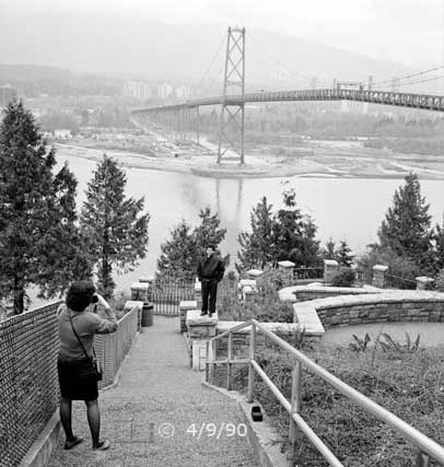 B/W photo: Photographer taking portrait with Lions Gate Bridge as background - Embedded text: 9/16/99