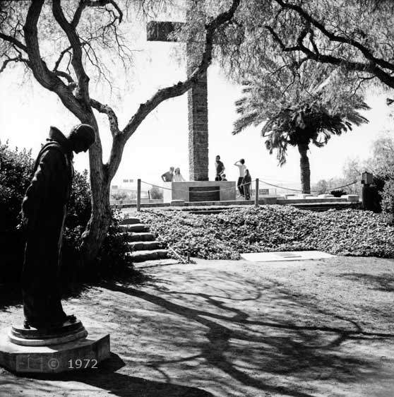 B/W photo: Father Serra statue with Serra Cross in background - Embedded text: 1972