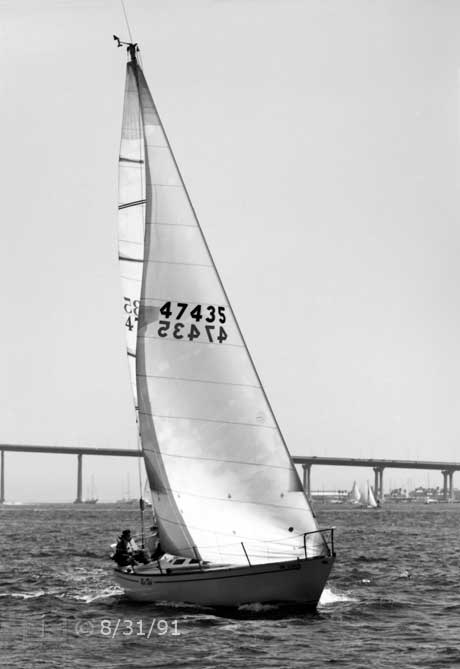 B/W photo: Bow view of boat under sail with Coronado Bridge in background - Embedded text: 8/31/91