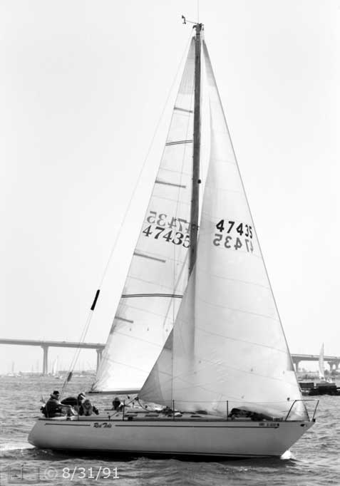 B/W photo: Starboard view of boat under sail with Coronado Bridge in background - Embedded text: 8/31/91