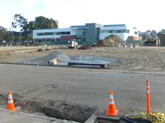 Color photo: View across now open field of new West City Campus building