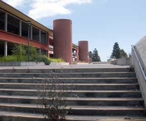 Color photo: View of a north side, Ross St., stairway entrance to City College, unkempt while construction underway