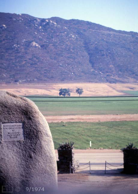 E6 Color image: Camera view from atop masonry fence behind monument